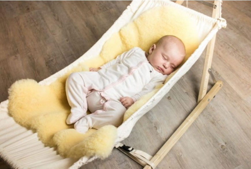 Bébé sur une peau de mouton dans une chaise longue