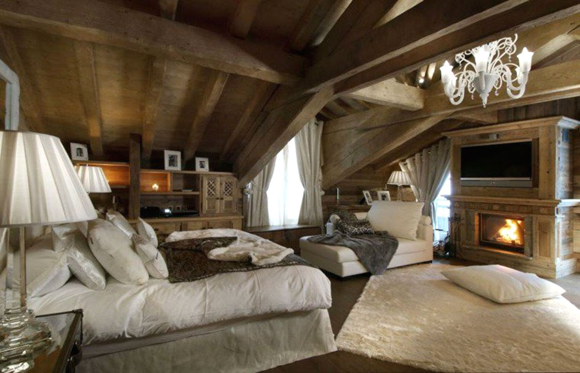 Chambre chalet avec tapis en peau de mouton blanche au sol et plaid en lapin gris sur la méridienne